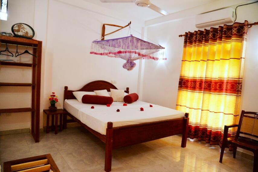 a bedroom with a large bed and a window at Neel's Guest House in Kosgoda