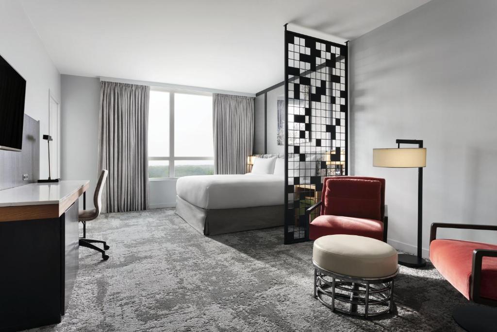 a hotel room with a bed and a chair at Loews Chicago O'Hare Hotel in Rosemont