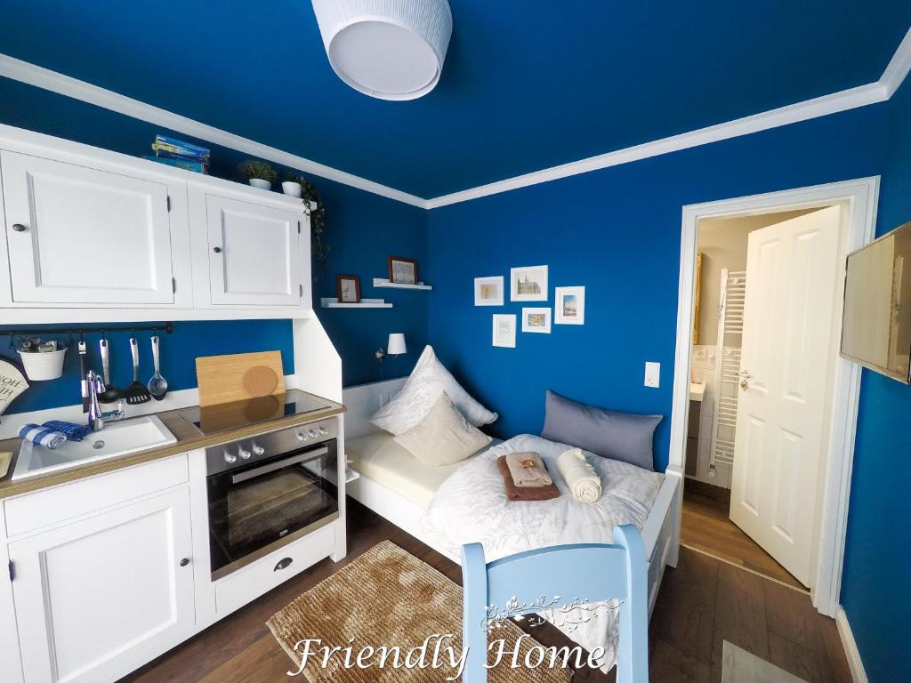 a blue kitchen with a small bed and a sink at Friendly Home - Einzelappartement "Trust" Köln Bonn Phantasialand in Brenig