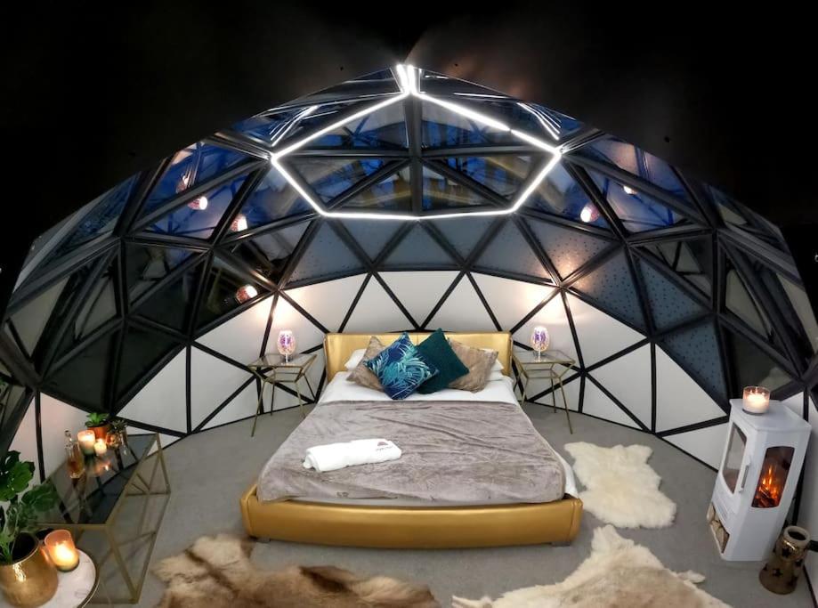 a room with a bed in a dome with lights at Romance - Stargazing - Hot tub & sauna! in Camborne