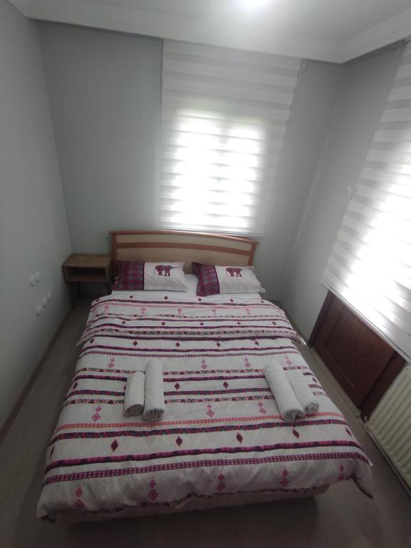a bedroom with a large bed with a red and white blanket at Ağva'da Villa in Sile