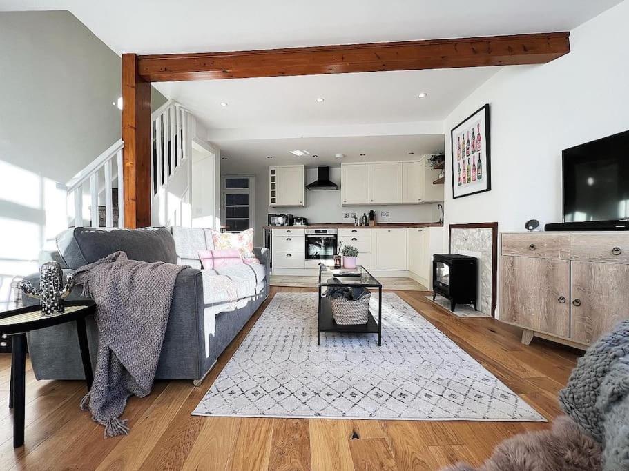 ein Wohnzimmer mit einem Sofa und einer Küche in der Unterkunft Quirky 3 Bedroom Town House in Clifton, Bristol in Bristol