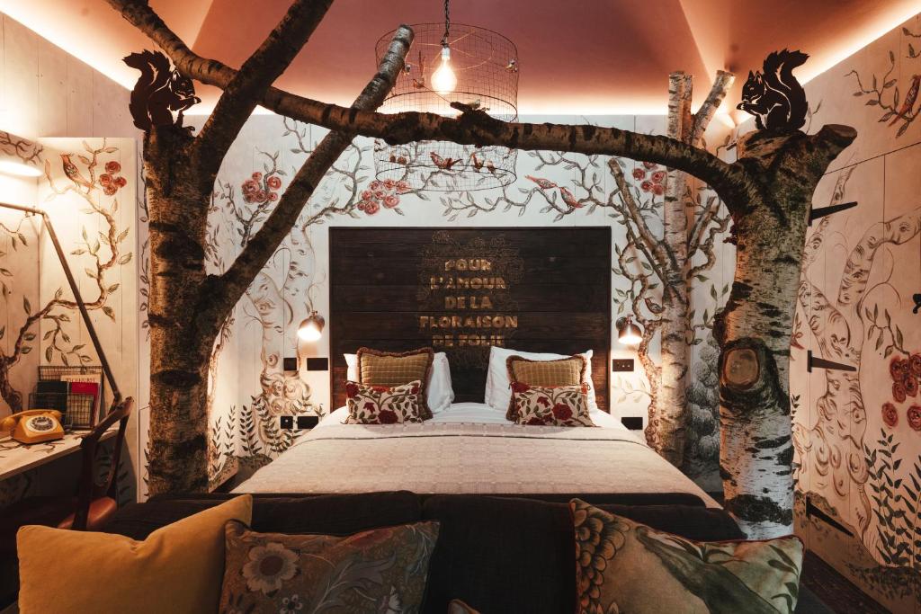 um quarto com uma cama com árvores na parede em The Bell in Ticehurst em Ticehurst