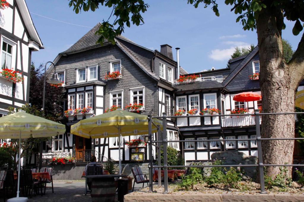a black and white building with umbrellas in front of it at Landhotel Albers in Schmallenberg
