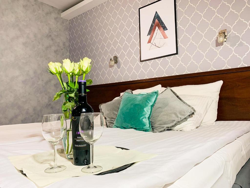 a bed with a table with wine glasses and flowers on it at Hotel Fero Express POKOJE KLIMATYZOWANE AC in Kraków