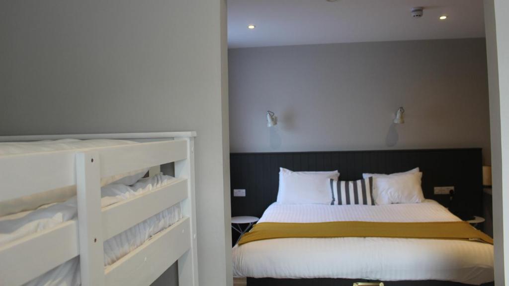 a bedroom with a bed and a bunk bed at Marine Hotel Ballycastle in Ballycastle