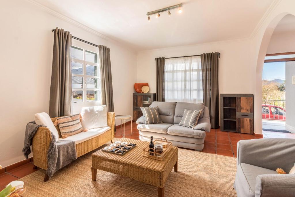 a living room with two couches and a table at Casa da Olides - T3 in Santana