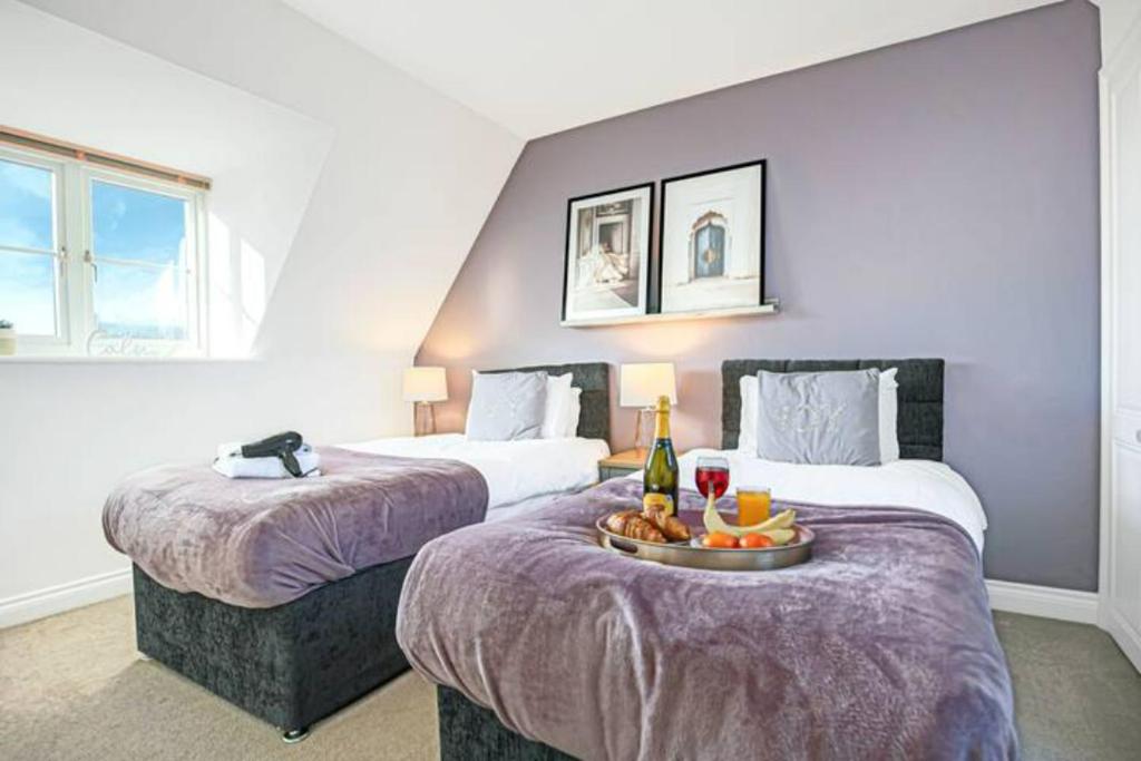 a hotel room with two beds with a tray of fruit at Berrywood House - Close to Northampton Town Centre - Free Parking, Fast Wifi, SmartTV with Netflix by Yoko Property in Northampton