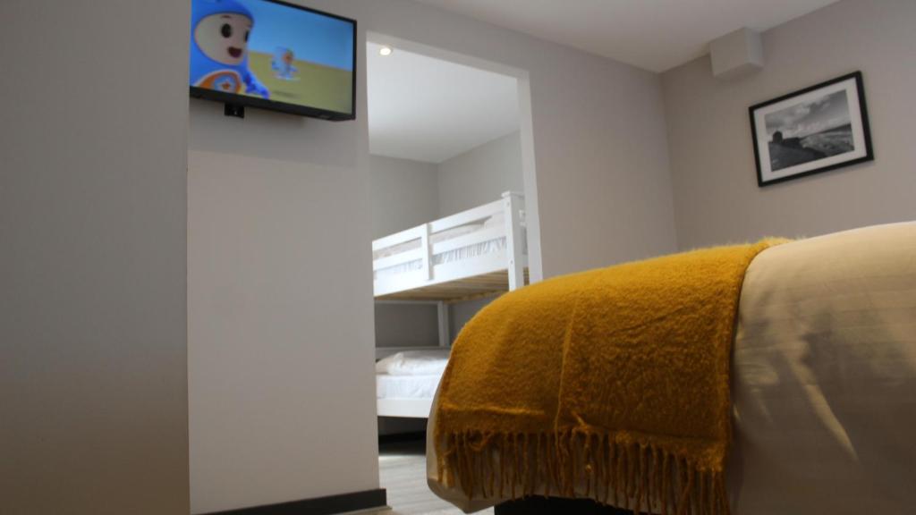 a bedroom with a bed and a tv on a wall at Marine Hotel Ballycastle in Ballycastle
