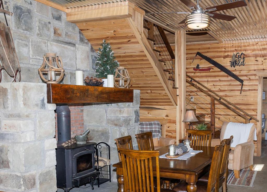 a living room with a fireplace and a table and a stove at The Lodge by On Cue Properties in Ghent
