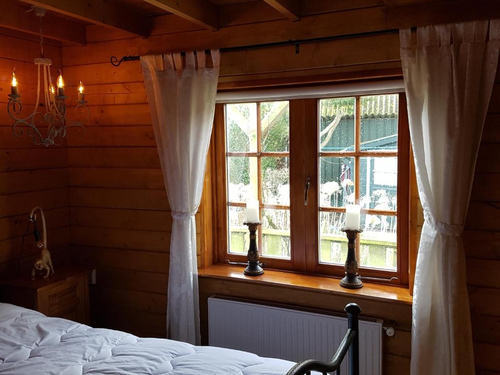 Schlafzimmer mit einem Bett und einem Fenster in der Unterkunft Romantisch Huisje nabij het strand in Julianadorp