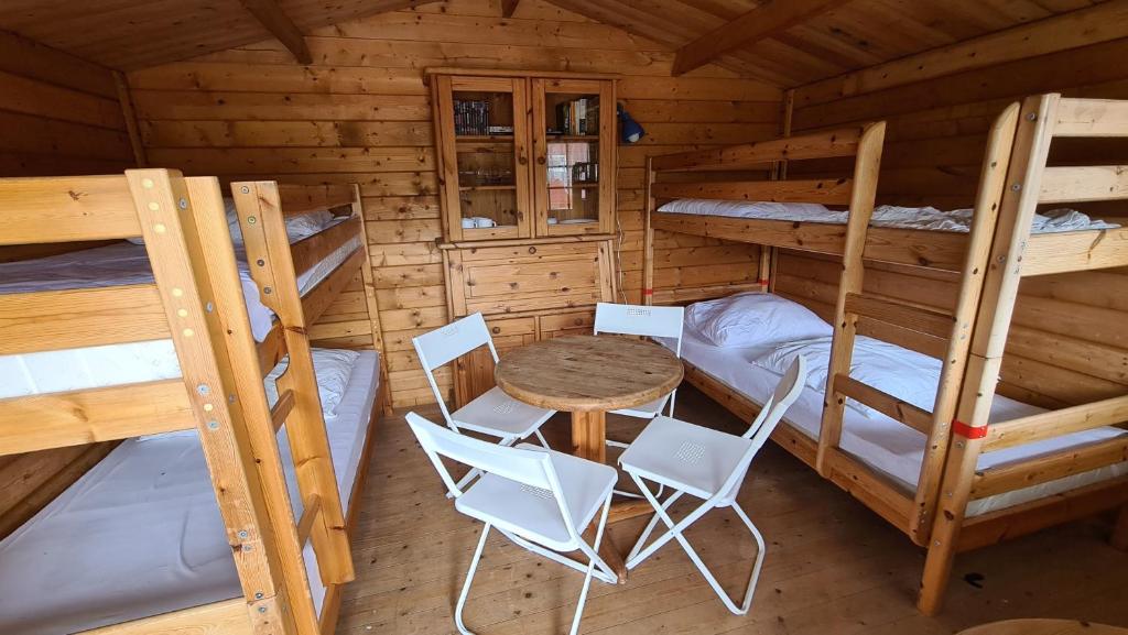 a room with two bunk beds and a table and chairs at Ferienholzhaus Strandbude mit Terrasse in Ahlbeck