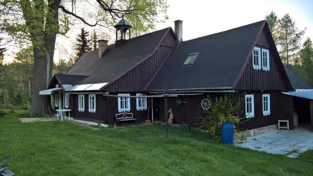 ein Haus mit einem Gamer-Dach mit einem Turm in der Unterkunft Chata v srdci Krkonoš in Kořenov