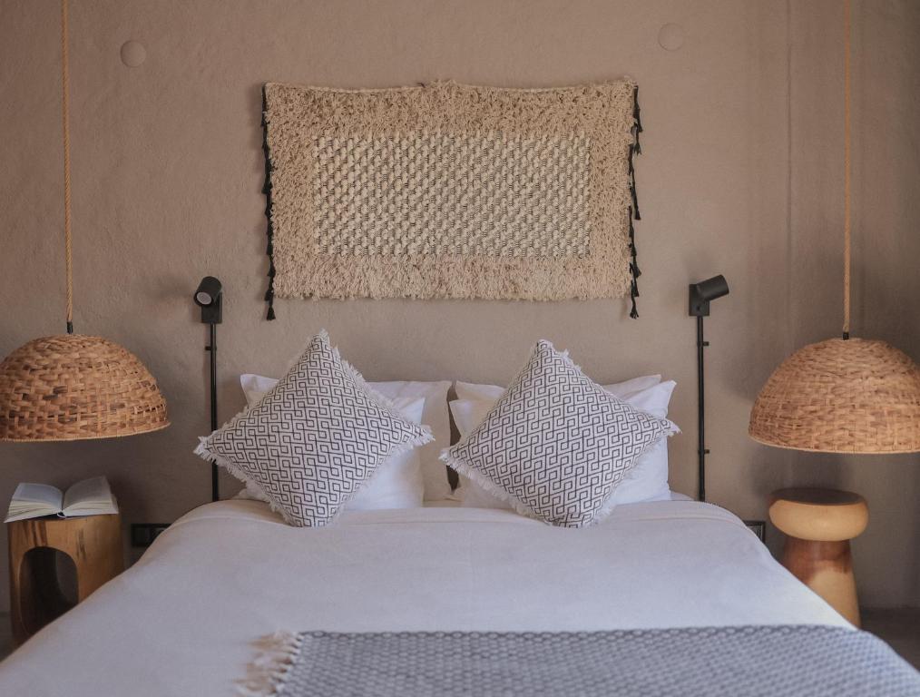 a bedroom with a white bed with two lamps at GAIA ALAÇATI in Alacati