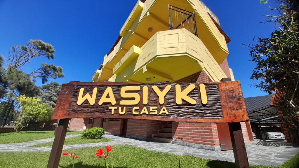a sign for the waikiki tu casa building at Complejo de Mar Wasiyki Villa Gesell in Villa Gesell
