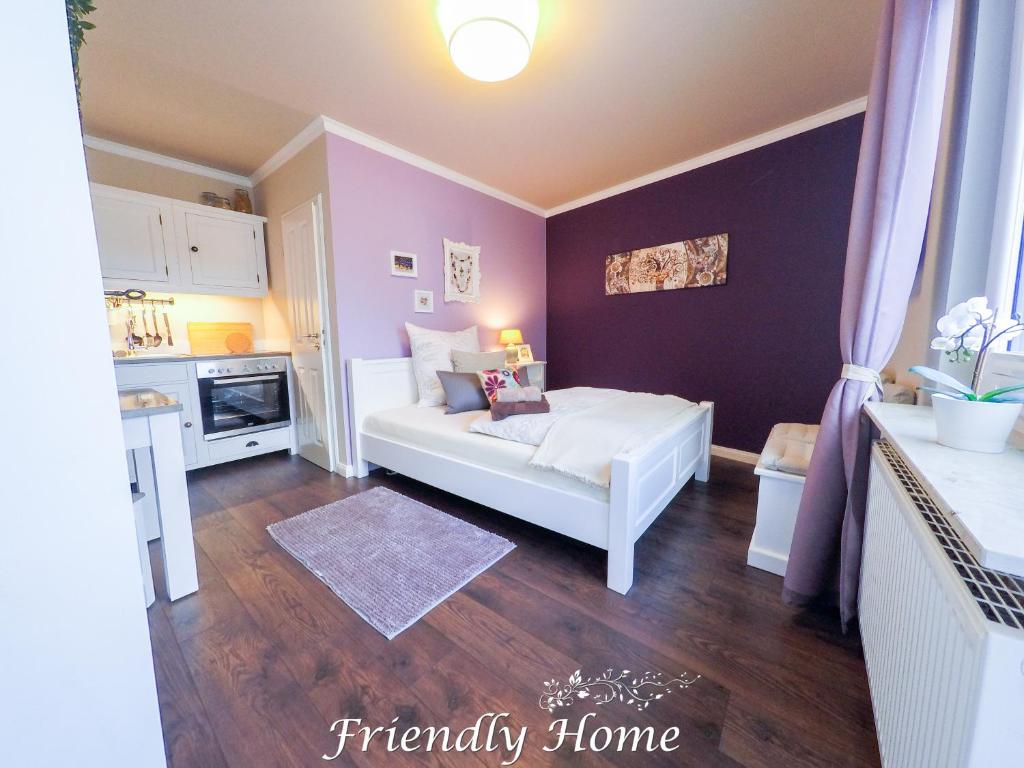 una camera con un letto bianco e una parete viola di Friendly Home - Doppelappartement "Purple" Köln Bonn Phantasialand a Brenig