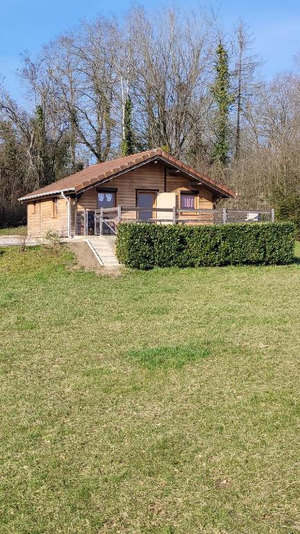 una casa sentada en un campo con un patio en Chalet des Grands Prés en Gercourt-et-Drillancourt