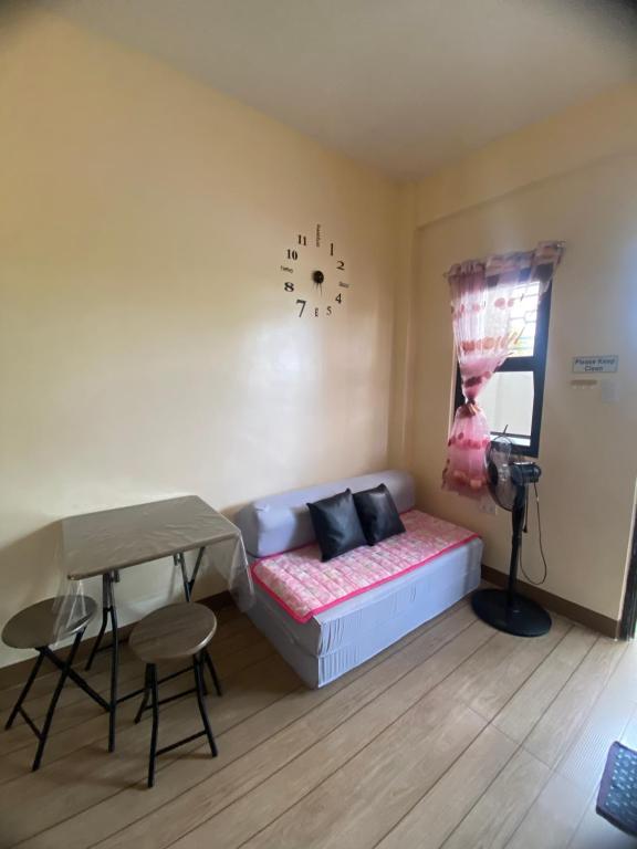 Mangangpico的住宿－SAN JOSE DEL MONTE BULACAN GUMAOK West,Delgados Place UNIT 2，客房设有一张床、一张桌子和一张桌子。