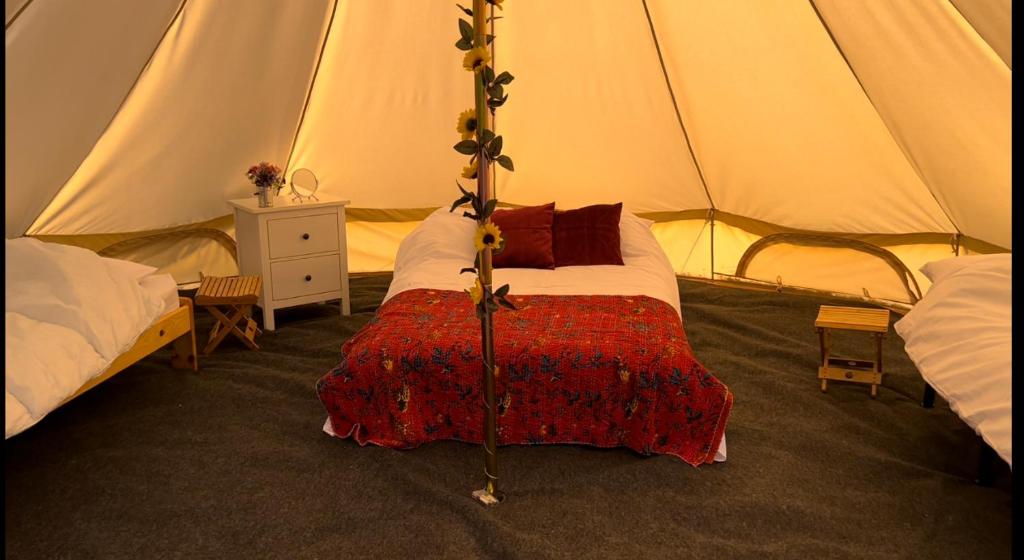 A bed or beds in a room at Strawberry Fields Glamping at Cottrell Family Farm