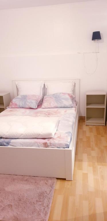 uma cama branca num quarto com um tapete em Magnifique F2 avec terrasse et parking, proche d'un parc et à 7 minutes à pieds de la Gare em Le Mée-sur-Seine