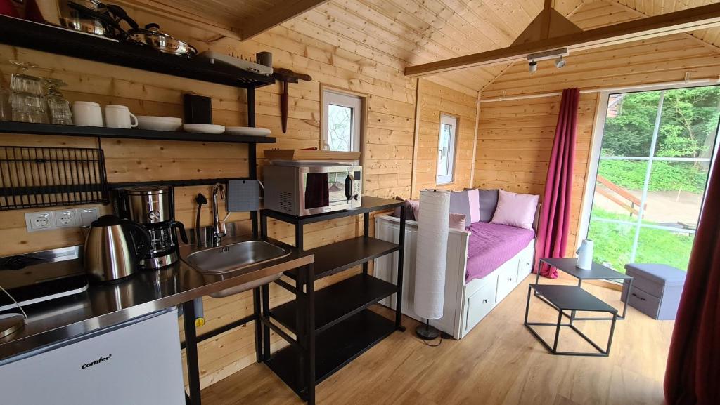 una cocina en una casa pequeña con cama en Tiny House Strandwagen mit Terrasse en Ahlbeck