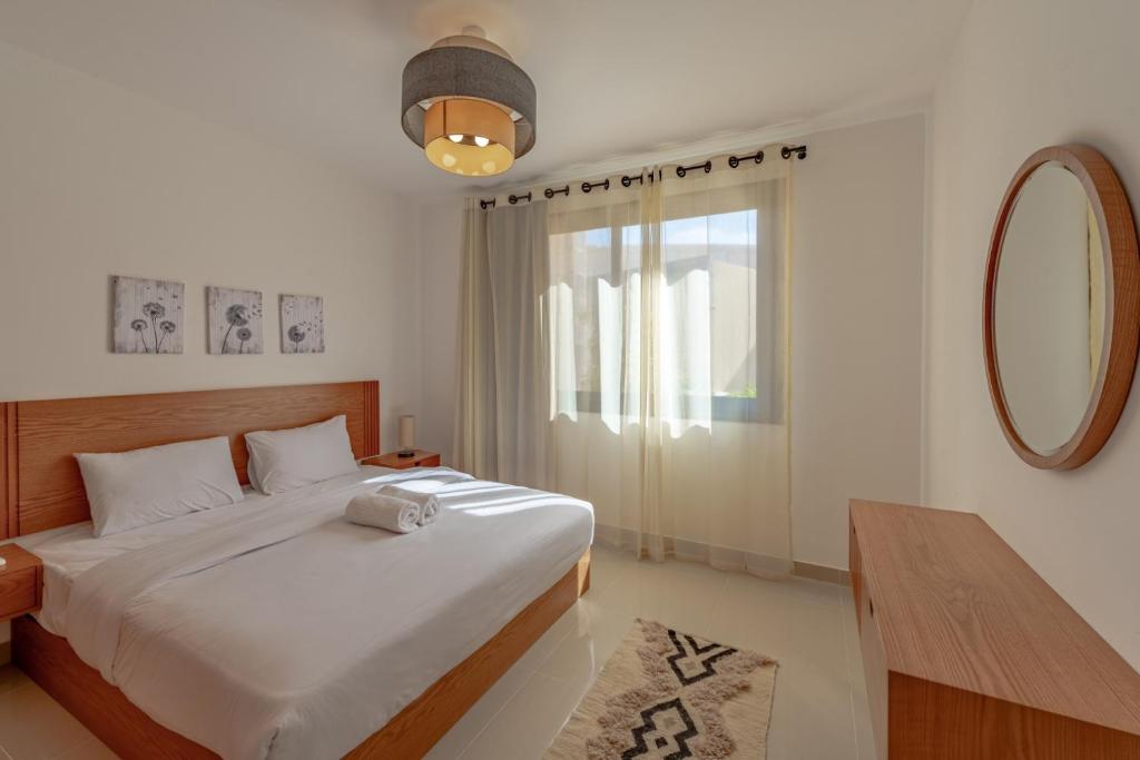 - une chambre avec un lit, une table et un miroir dans l'établissement Modern 1-Bedroom Apartment in G-Cribs, El Gouna, pool access, à Hurghada