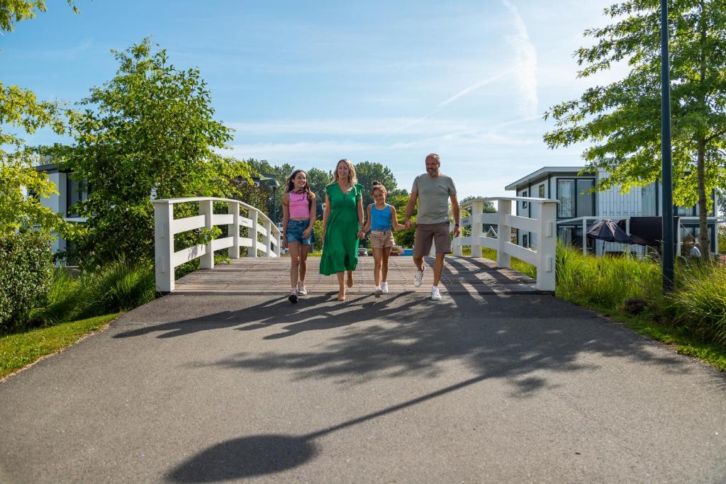 une famille traversant un pont dans l'établissement Comfort Rooms by EuroParcs Bad Hulckesteijn, à Nijkerk