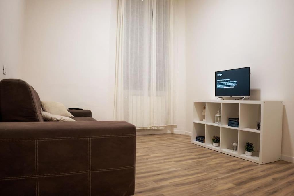 a living room with a couch and a flat screen tv at Casa Emilia [centro storico] in Imola