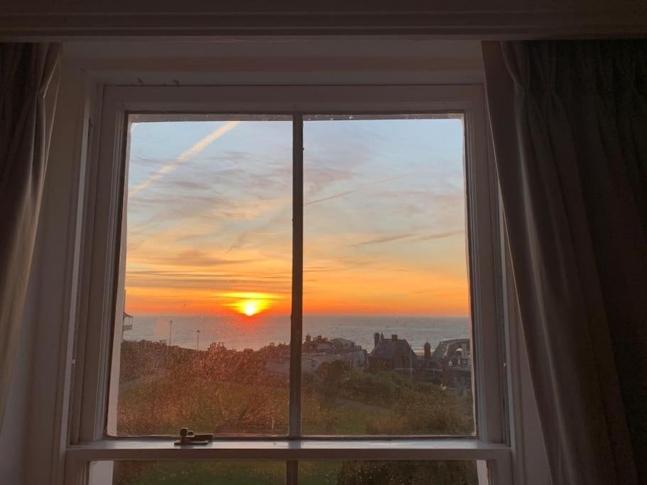 ein Fenster mit Blick auf den Sonnenuntergang in der Unterkunft Georgian 5 storey house, seaviews, cinema room in Kent