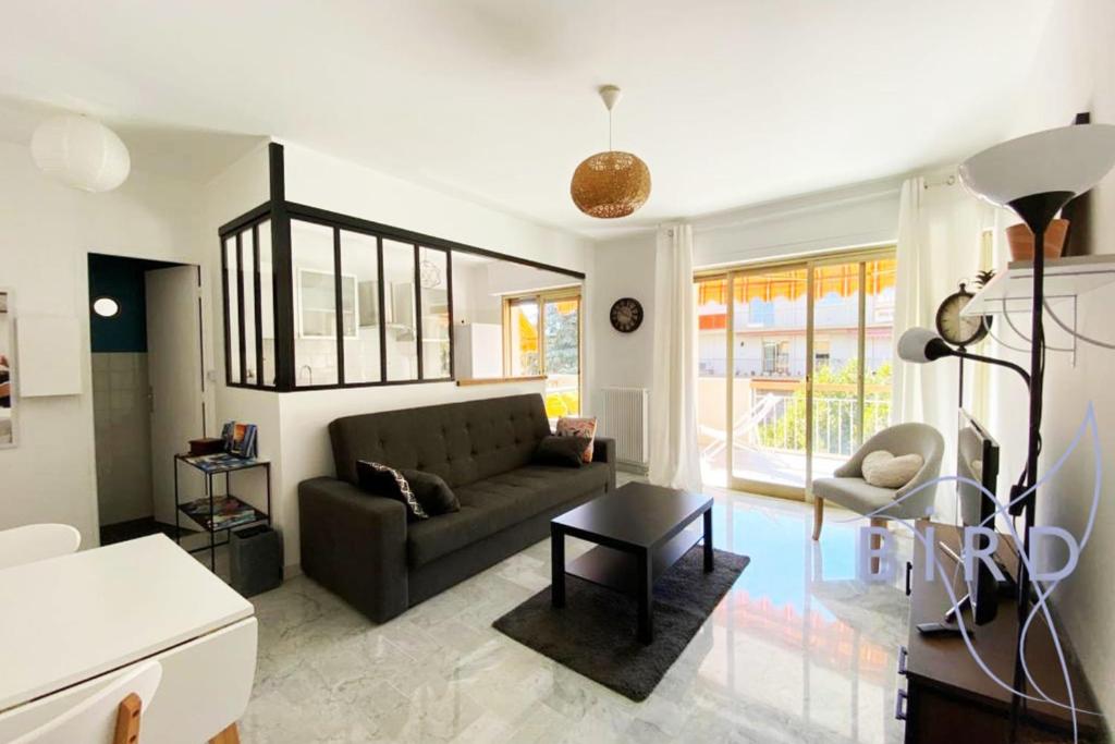 un salon avec un canapé et une table dans l'établissement Bright flat near to the beach & harbor, à Saint-Laurent-du-Var