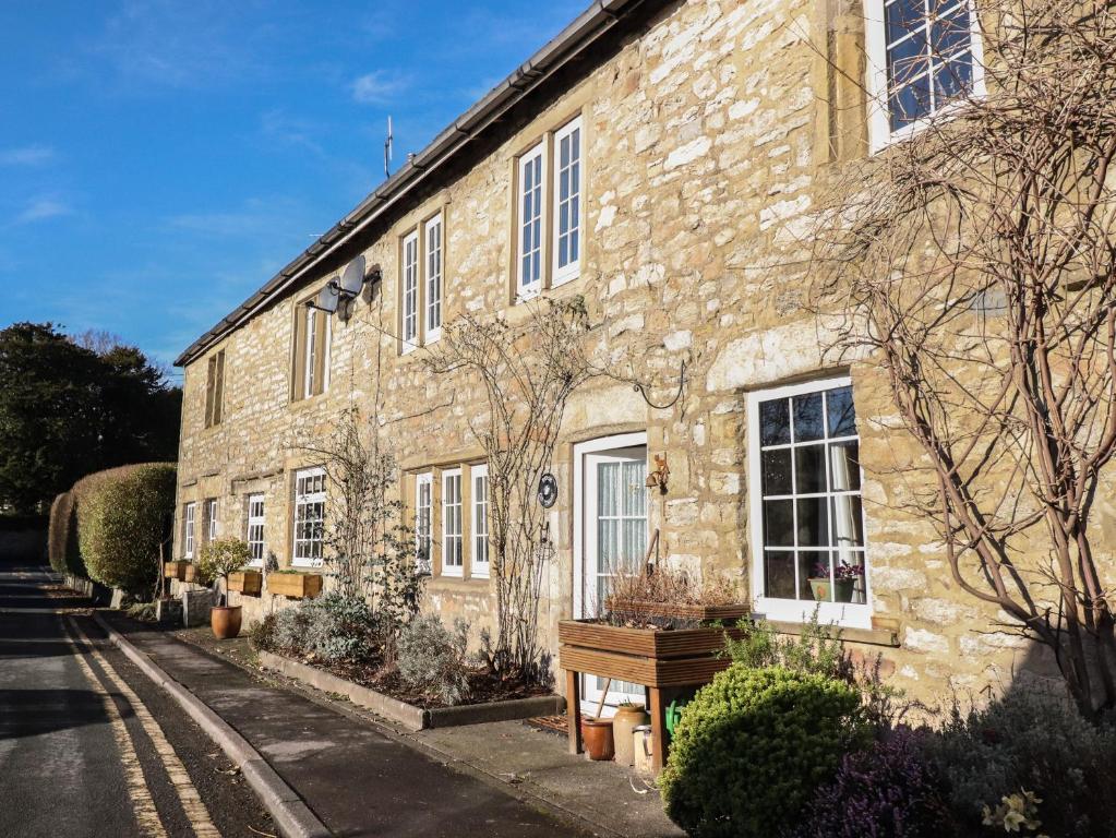 a large stone building with windows on a street at Rose Cottage in Settle