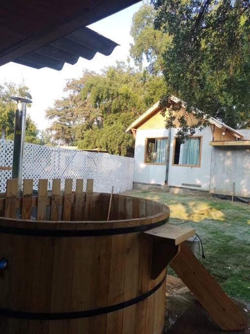 Cabaña de campo en Pirque في بيركو: برميل خشبي في ساحة مع منزل