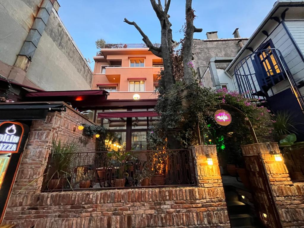 un edificio con un árbol delante de él en BKM Hostel en Estambul