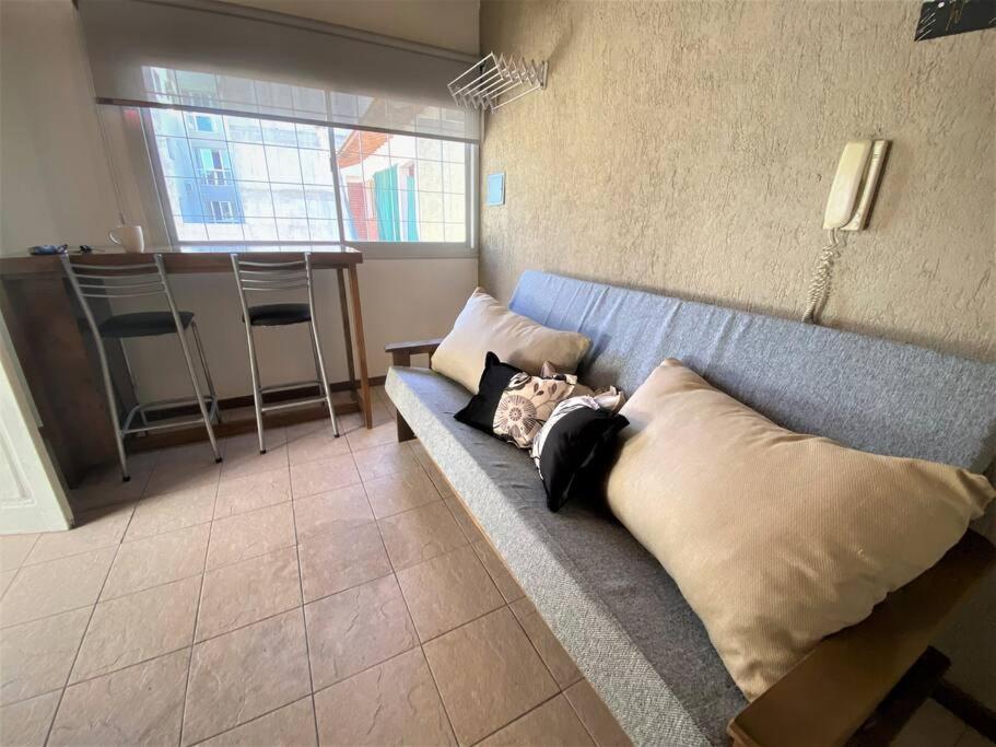 un sofá azul en una habitación con almohadas en Departamento zona Top en Godoy Cruz