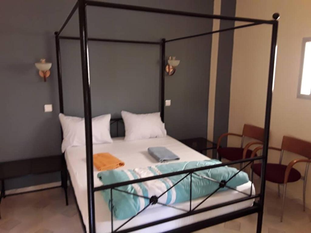 a bedroom with a bed with a black metal frame at HÔTEL ETOILE DU SUD in Saint-Louis