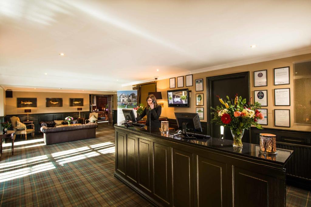 a woman standing at a bar in a hotel lobby at Leonardo Boutique Huntingtower Perth in Perth