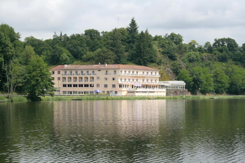 a large building next to a large body of water at Logis Cosy - Hôtel Le Moulin Neuf - Chantonnay in Chantonnay