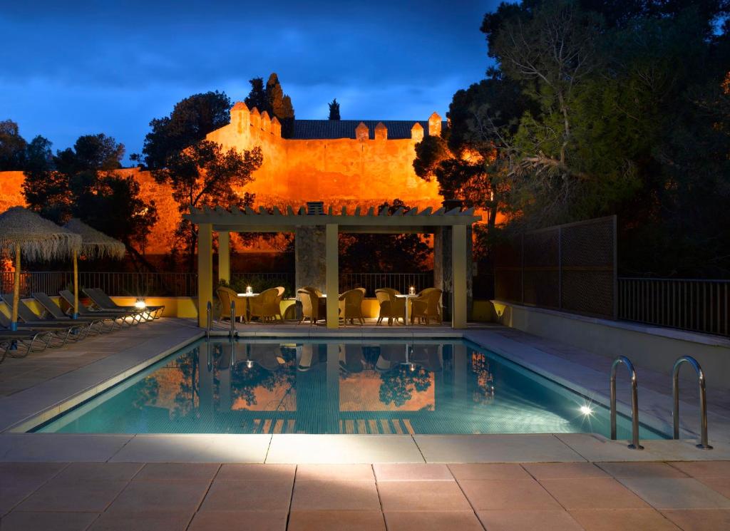 een zwembad met een prieel naast een huis bij Parador de Málaga Gibralfaro in Málaga