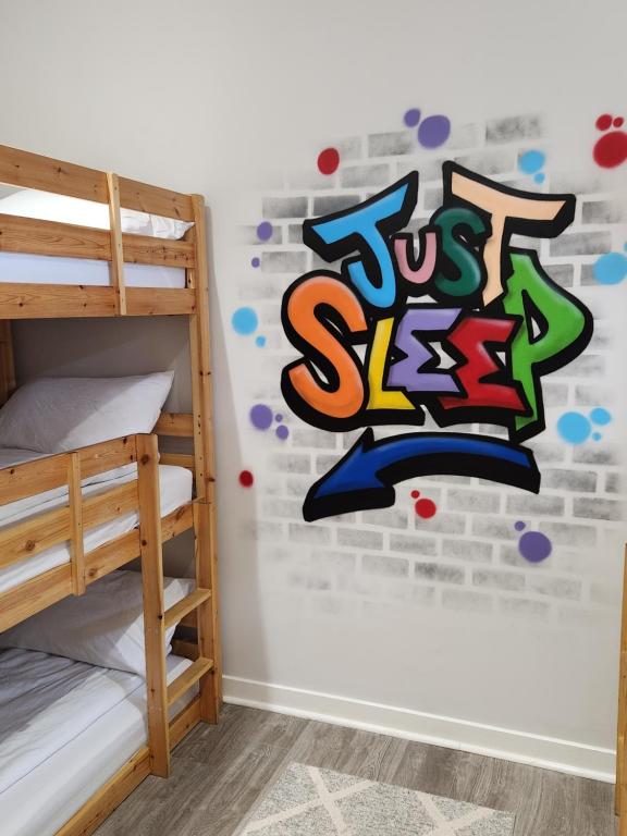 a bedroom with a mural of just sleep on the wall at JUST SLEEP Hostel in Edinburgh