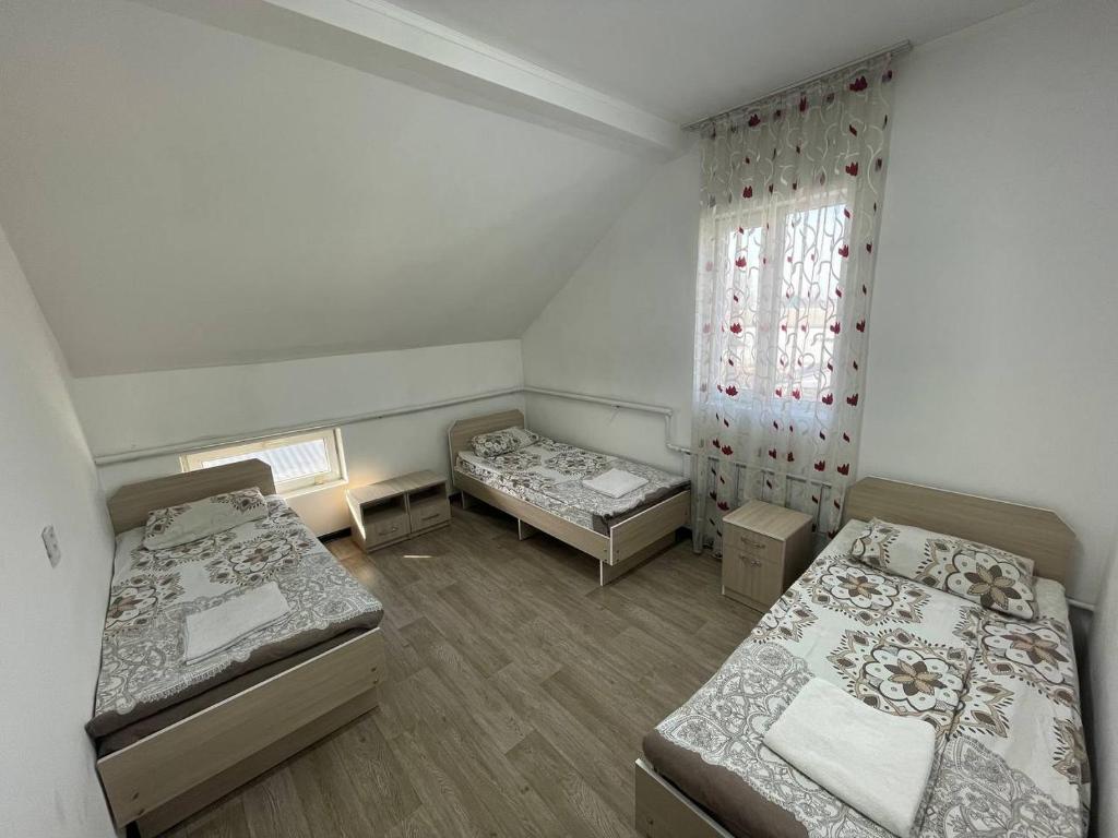 um quarto com duas camas e uma janela em Bishkek Backpackers em Bishkek