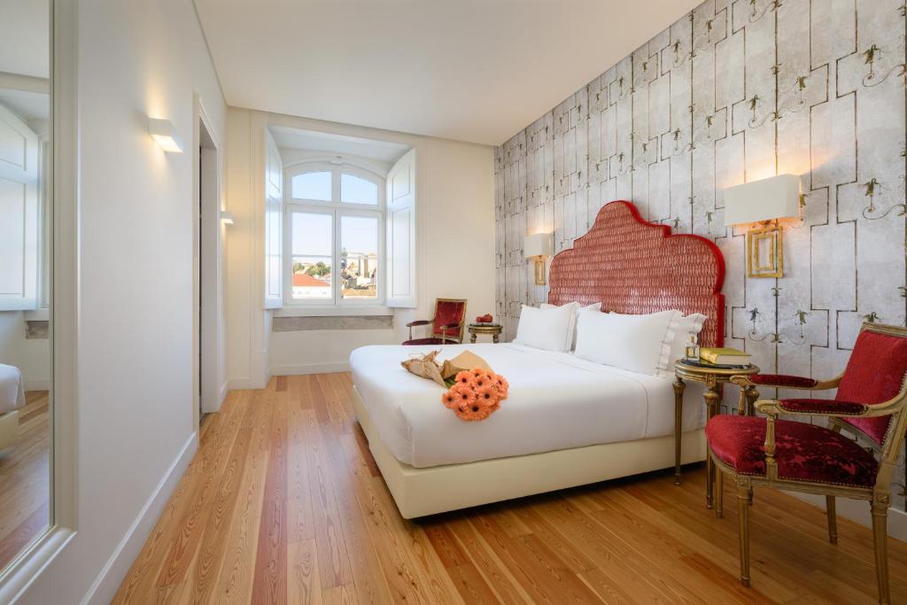 a bedroom with a large white bed with a red headboard at Residentas Arco do Bandeira in Lisbon