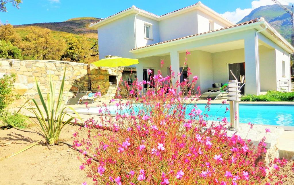 ein Haus mit rosa Blumen vor einem Pool in der Unterkunft Arinella Villas in Farinole