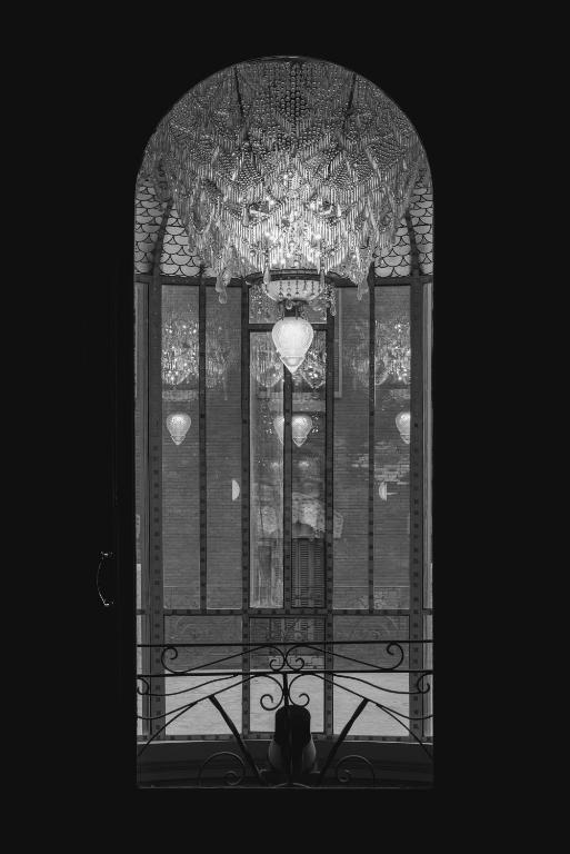 a window with a chandelier in front of a window at El Palauet Royal Suites in Barcelona