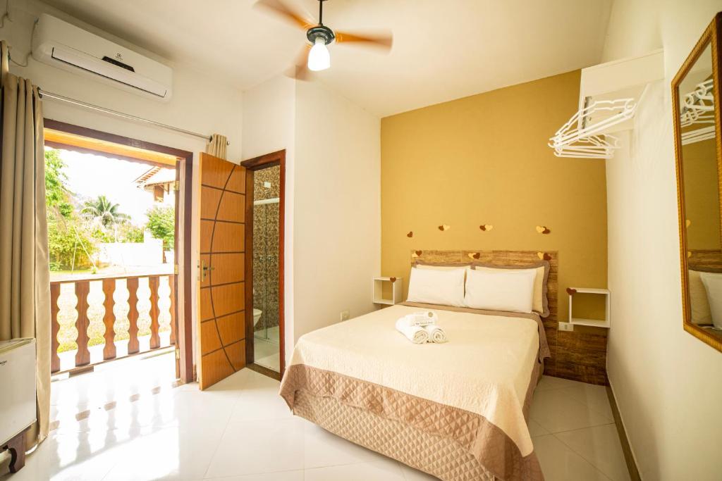 ein Schlafzimmer mit einem Bett und einem Balkon in der Unterkunft Pousada Cantinho do Sossego Paraty in Paraty