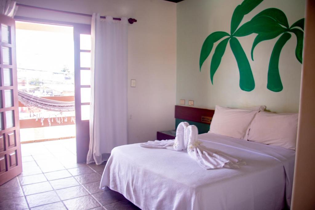1 dormitorio con 1 cama con una planta en la pared en Hotel Pousada Mahon Mar, en Praia do Frances