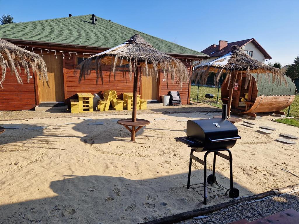 grill i parasol przed domem w obiekcie Apartament z Tężnią Solankową, Sauną, Kominkiem LED i Śniadaniem nad Jeziorem Żywieckim w mieście Zarzecze