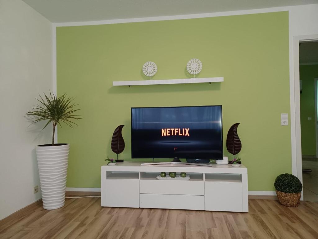una sala de estar con TV en un armario blanco en H&A Apartment Baden Baden en Baden-Baden