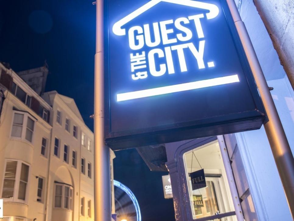 un primer plano de una señal para una ciudad invitada en Guest And The City, en Brighton & Hove
