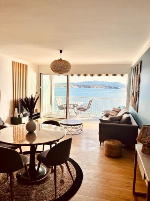 salon ze stołem i widokiem na ocean w obiekcie Les Baux 3 w mieście Sanary-sur-Mer