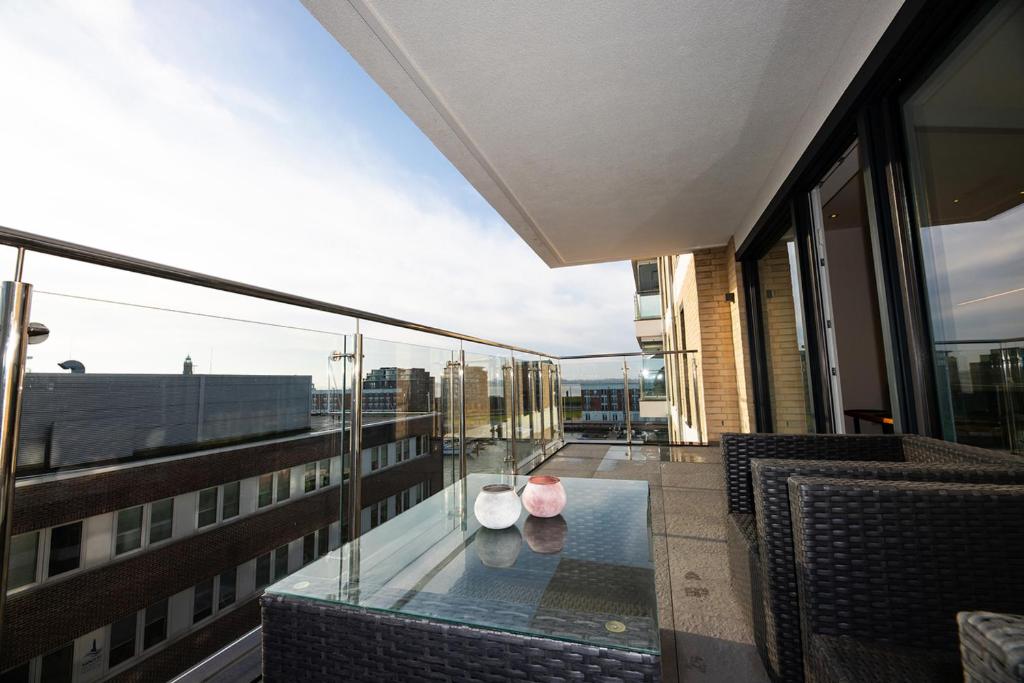 een balkon met een glazen tafel en stoelen in een gebouw bij FeWo "B523" 4 Personen in Bremerhaven